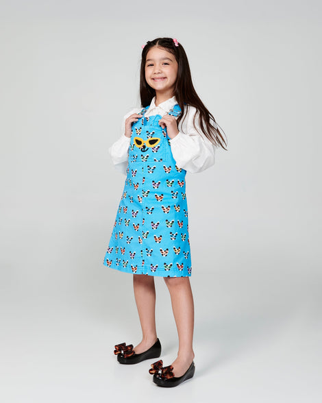 Child model in a blue dress wearing a pair of black kids Ultragirl Classic Bow kids flats with tortoise bow