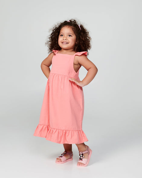 Child model in a coral dress wearing a pair of pink  Play Mickey & Minnie sandals