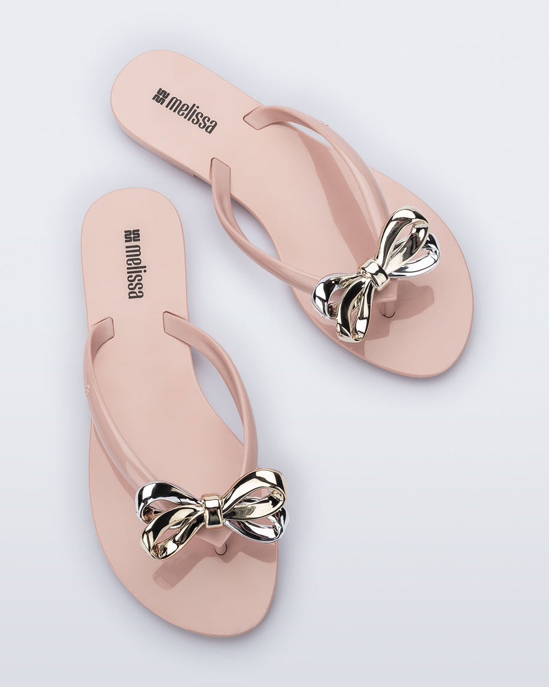 Top view of a pair of Harmonic Eclipse flip flops with bow.