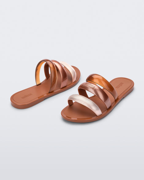 Back and angled view of a pair of brown Eclipse Slides with gold, bronze and brown straps.