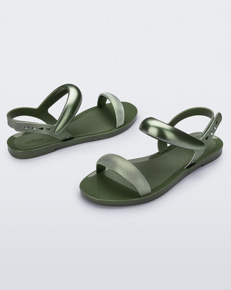 Angled view of a pair of green Eclipse Sandals with glitter green straps.