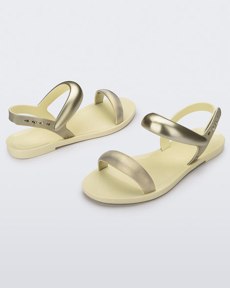 Angled view of beige Eclipse Sandals with gold straps.