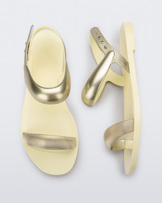 Top and side view of a pair of beige Eclipse Sandals with gold straps.