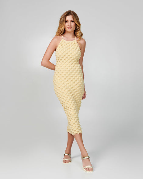 Model in yellow dress wearing a pair of beige Eclipse Sandals with gold straps.
