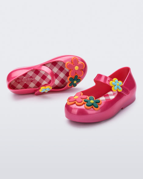 Angled and top view of a pair of pink Sweet Love Picnic baby flats with flowers