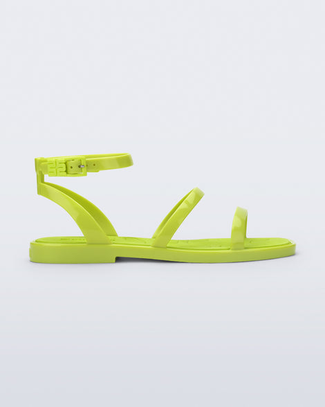 Side view of the Melissa heat neon green sandal on a light gray background
