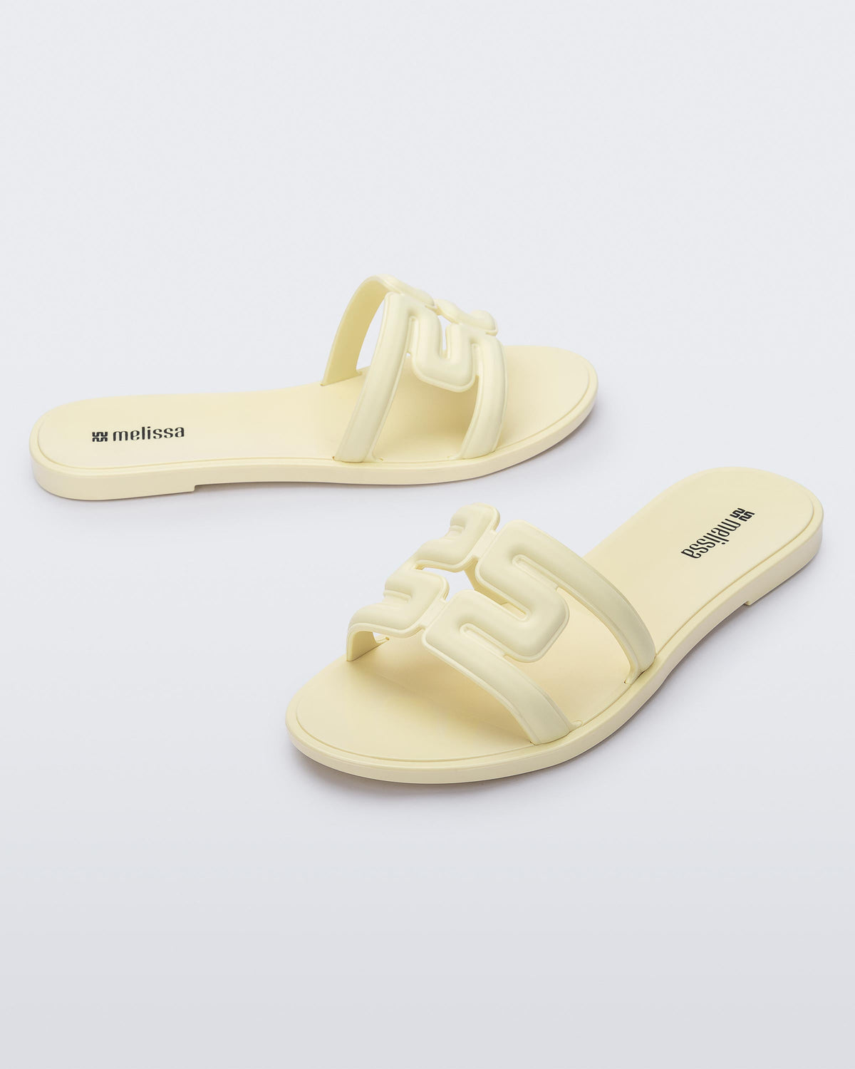 Angled view of a pair of beige M Slides.