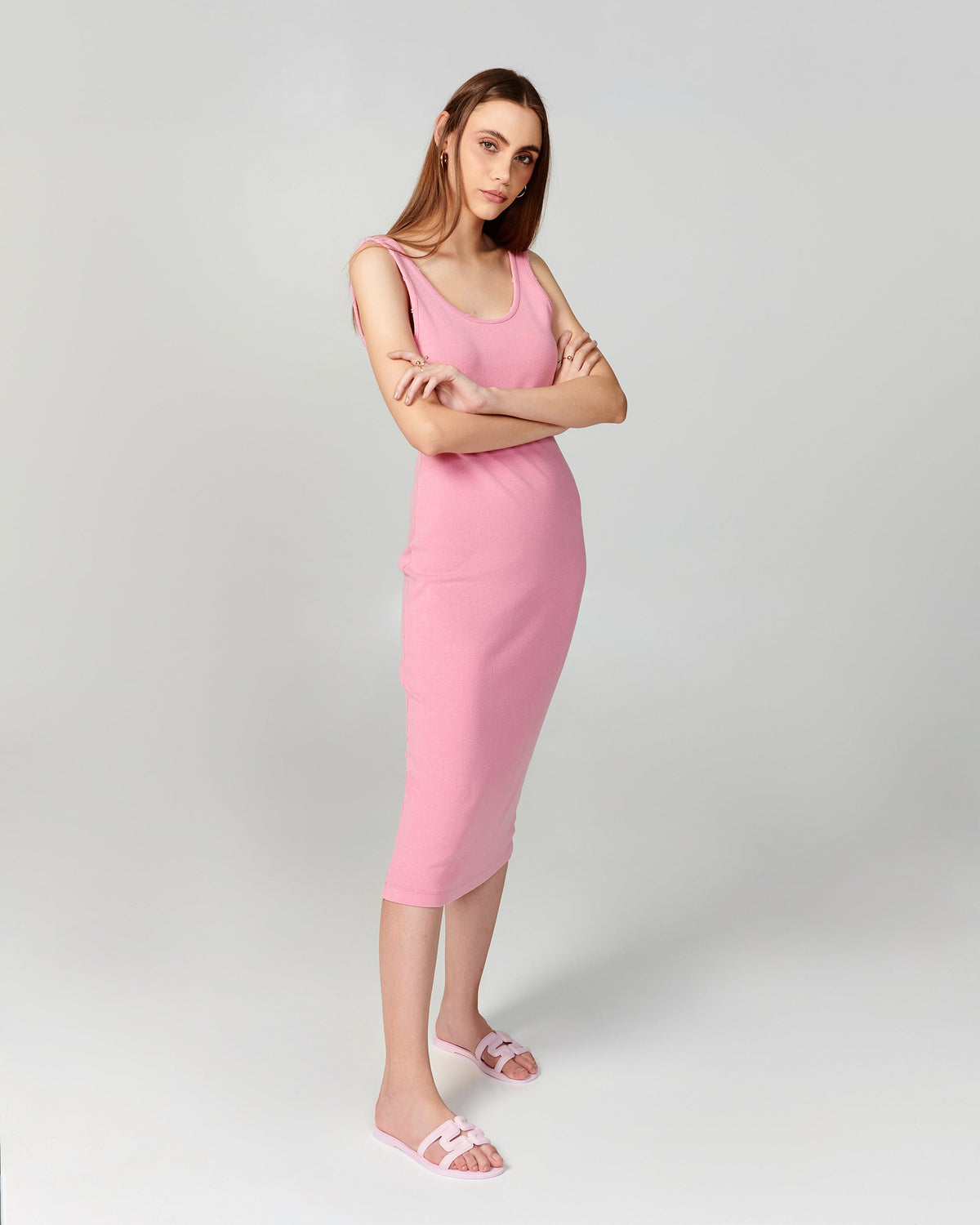 Model in a pink dress wearing a pair of light pink M Slides.