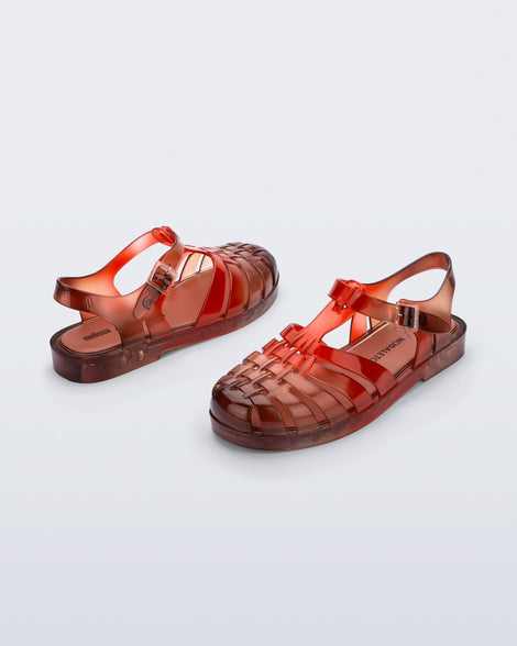 Angled view of a pair of transparent red Possession + Nodaleto fisherman sandals