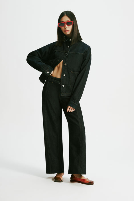 Model in a black pantsuit wearing a pair of transparent red Ruby + Nodaleto flats