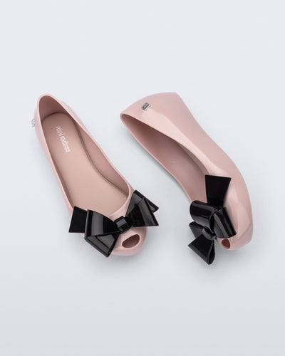 Top and side view of a pair of pink Ultragirl Classy kids ballerina flats with black bow