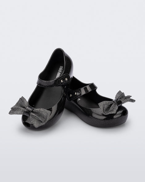 Angled view of a pair of black glitter Ultragirl Sweet baby ballerina flats