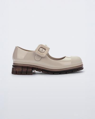 Side view of a beige with brown sole June kids mary jane with matte toe cap