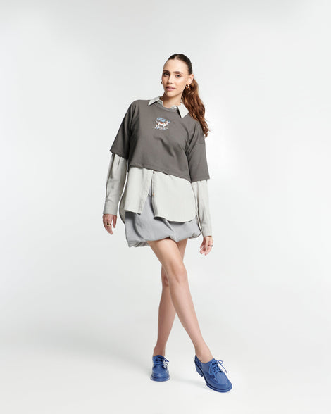 Model in a beige outfit wearing a pair of blue Tailor loafers