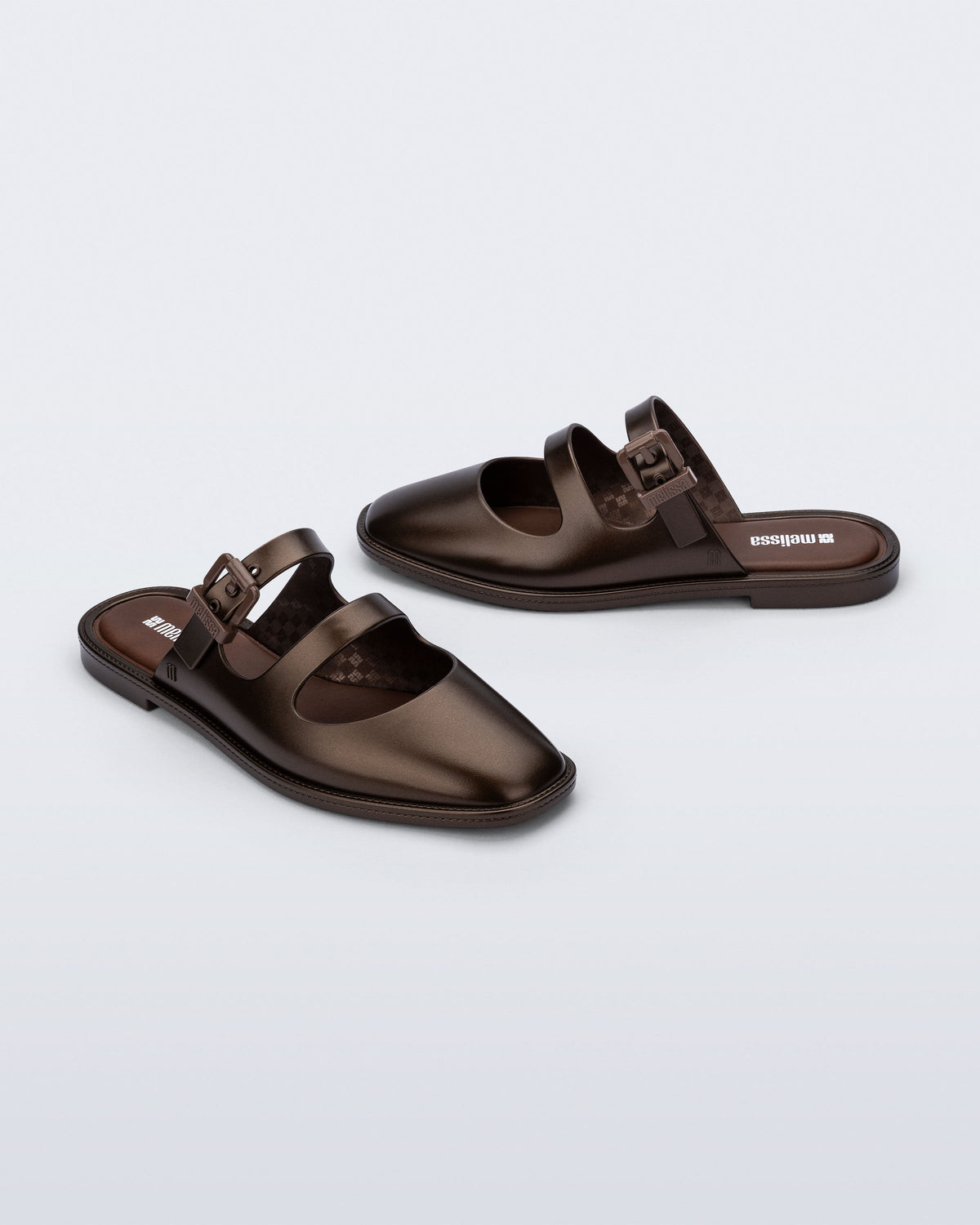 Side and angled view of a pair of bronze Anastasia mule slides