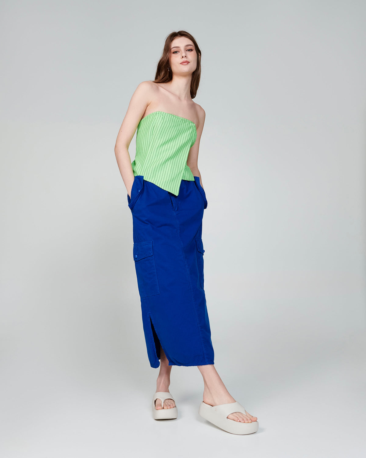 Model in a blue skirt and green top wearing a pair of beige Free Platform Thongs
