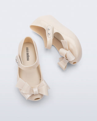 Top and side view of a pair of beige Ultragirl Classy baby ballerina flats with beige bow