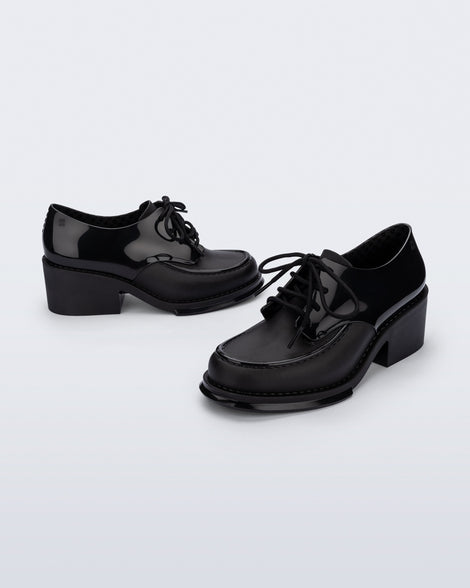 Side and angled view of a pair of black Tailor loafers