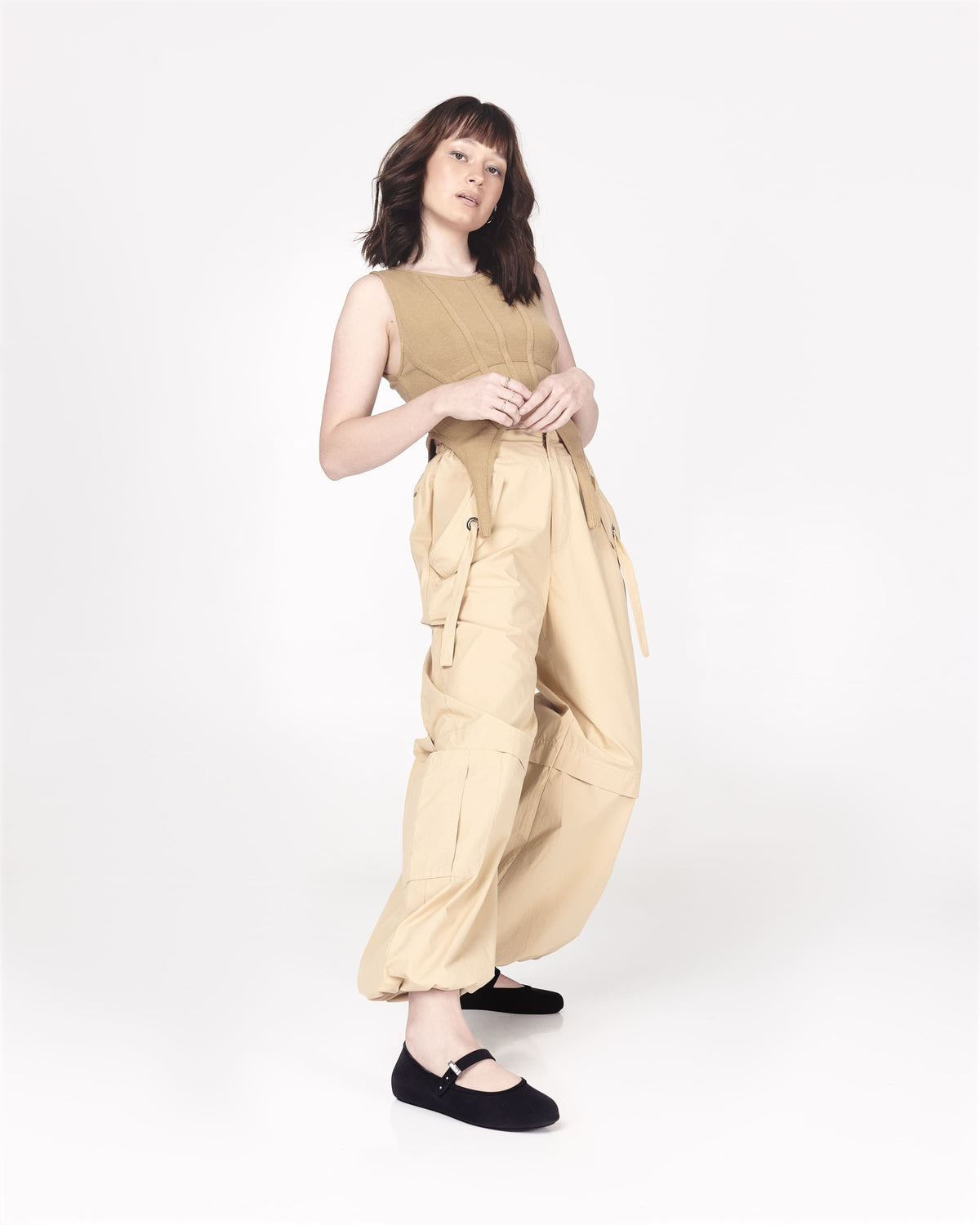Model in a beige outfit wearing a pair of black Soft adult flats with strap and silver buckle