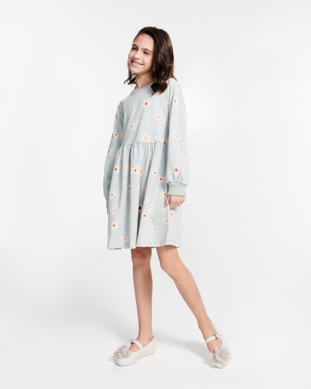 Child model in a blue dress wearing a pair of beige Soft Ballerina Petals kids flats
