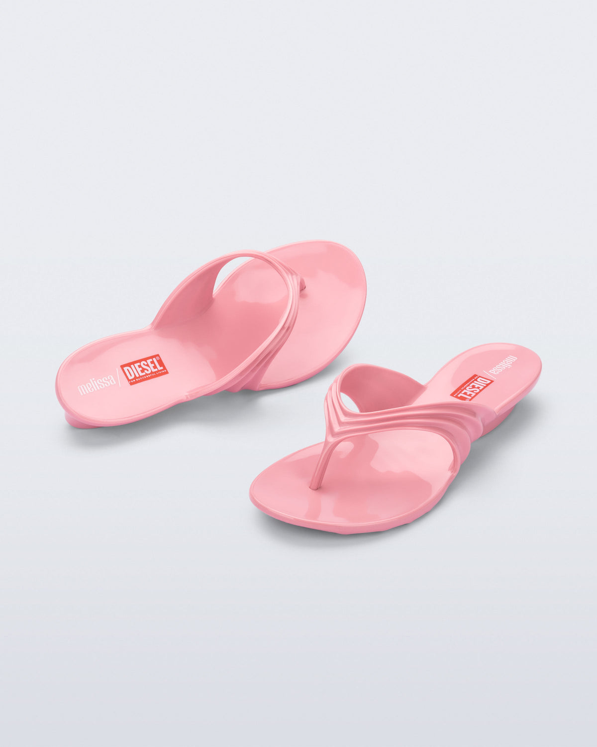 Top and angled view of a pair of pink Flip Flop + Diesel sandals