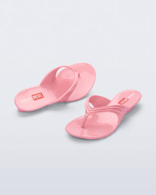 Top and angled view of a pair of pink Flip Flop + Diesel sandals