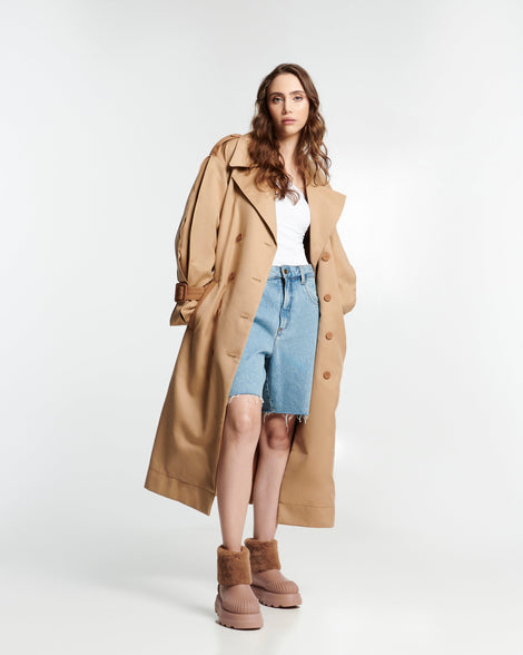 Model in a white button down shirt with raincoat and jean shorts wearing a pair of beige Warm Boots with fuzzy cuff and insole