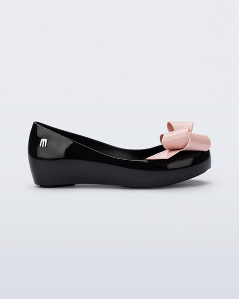 Side view of a black Ultragirl Classy kids ballerina with pink bow.