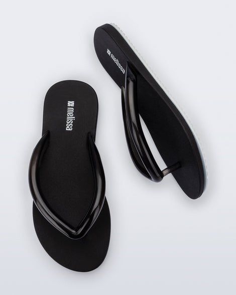 Top and side view of a pair of black Flip Flop Airflow sandals with white bottoms.