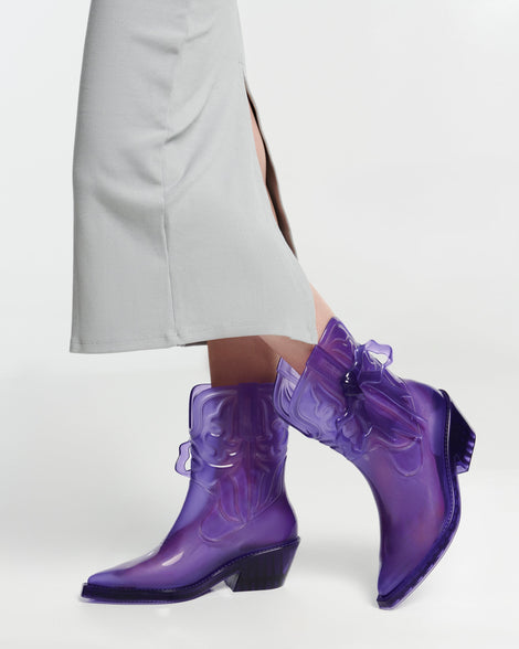 Model's legs in a pair of transparent purple Texas + Maldito boots