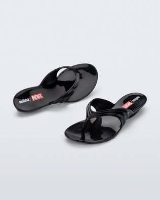 Top and angled view of a pair of black Flip Flop + Diesel sandals