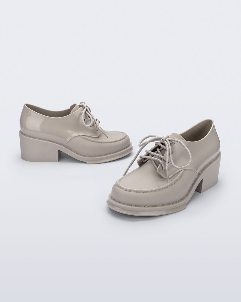 Side and angled view of a pair of beige Tailor loafers