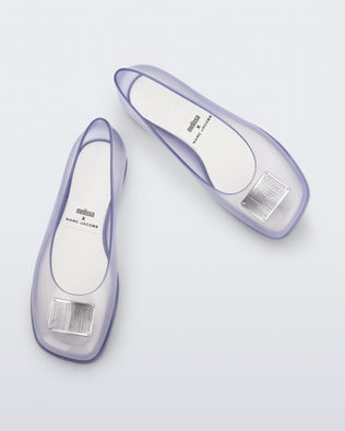 Top and angled view of a pair of clear silver Ruby + Marc Jacobs flats