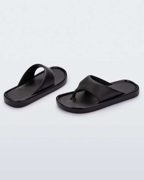 Angled view of a pair of black Float flip flops