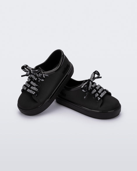 Angled view of a pair of black baby Hip M Lover sneakers with laces