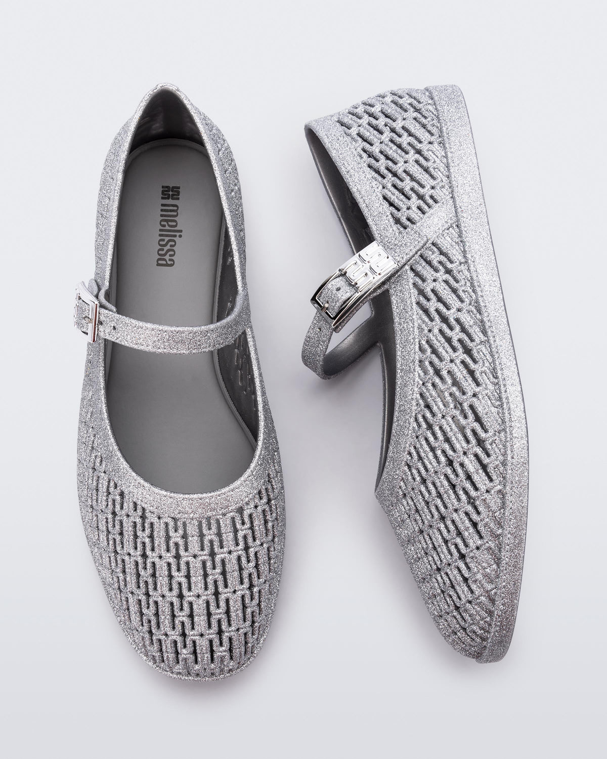 Top and side view of a pair of silver glitter Harper flat with strap
