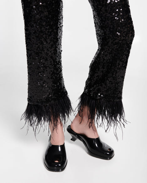 Model's legs in black pants wearing a pair of black Gaia kitten heels with peep toe