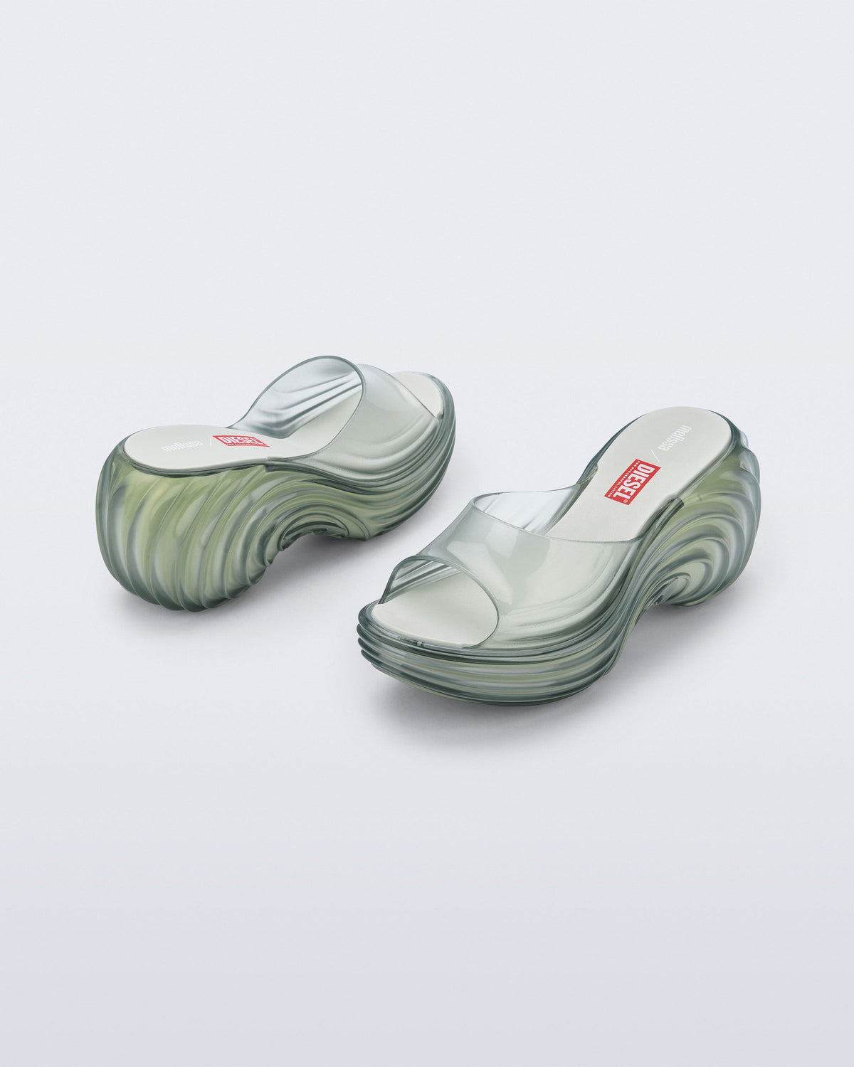 Back and side view of a pair of transparent green Platforms + Diesel slides