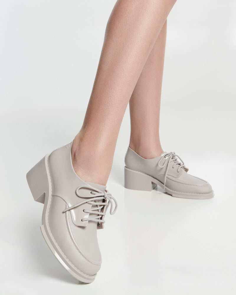 Model's legs in a pair of beige Tailor loafers