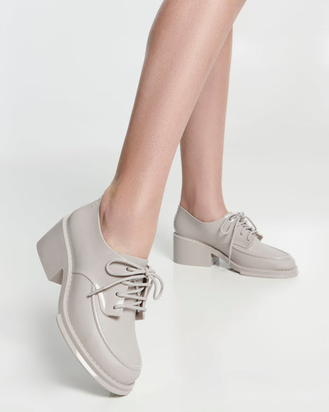 Model's legs in a pair of beige Tailor loafers