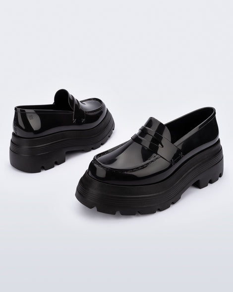 Angled view of a pair of black Royal High + Undercover platform loafers.