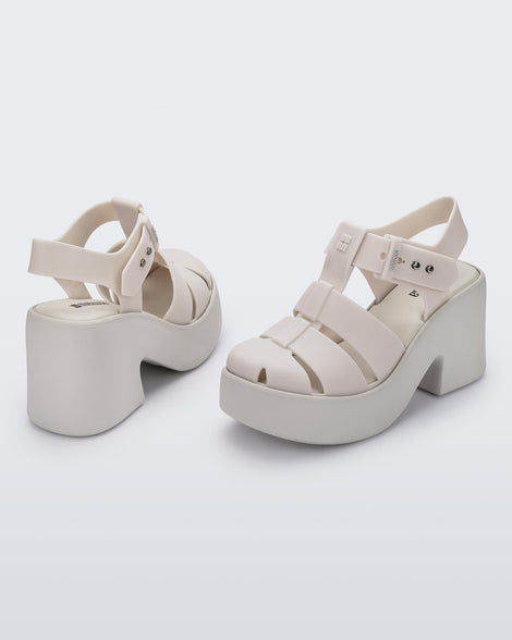Back and angled view of a pair of matte beige Lulu platform heel sandals