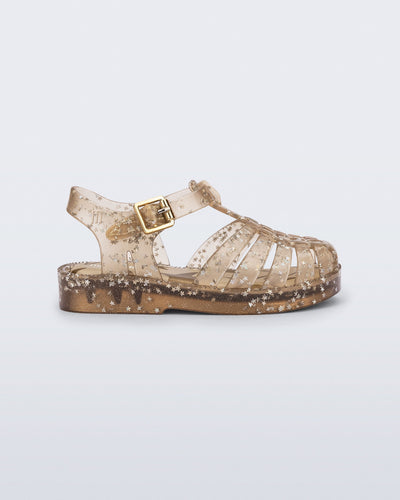 Side view of a clear beige Possession baby sandal with star glitter