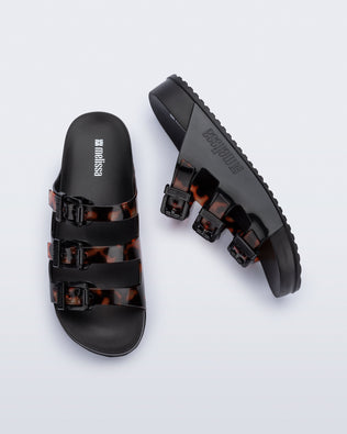 Top and side view of a pair of black Cozy Stripes slides with tortoise colored straps