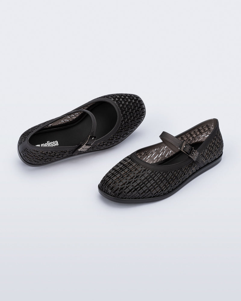 Top and angled view of a pair of clear black Harper flat with strap