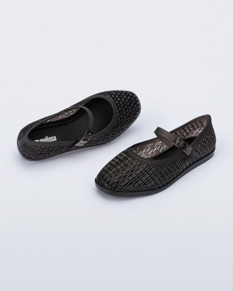 Top and angled view of a pair of clear black Harper flat with strap