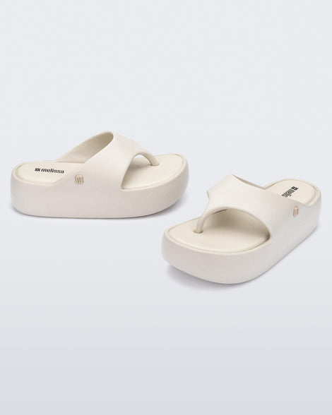 Side and top view of a pair of beige Free Platform Thong sandal