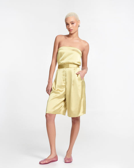 Model in gold satin outfit wearing a pair of clear pink Possession Ballerina flats