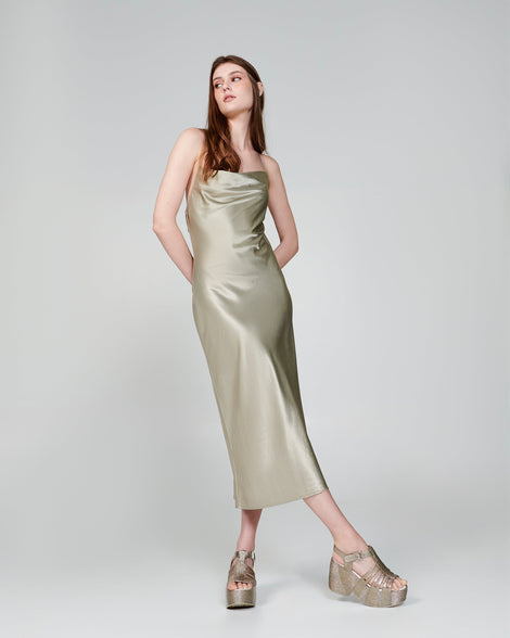 Model in a beige dress wearing a pair of glitter gold Station 79 platform heels with ankle strap