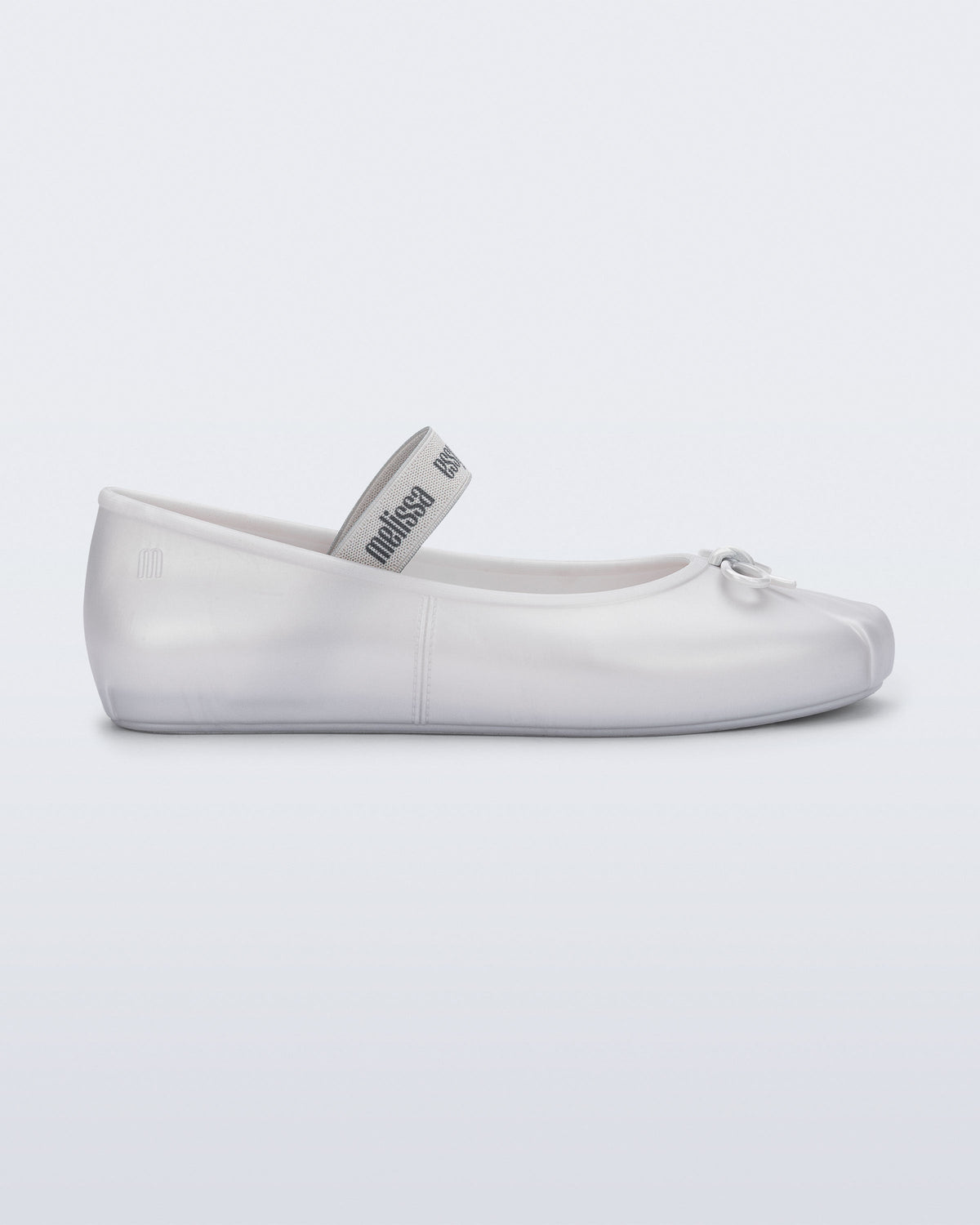 Side view of a pearly white Sophie flat with top elastic strap and small bow